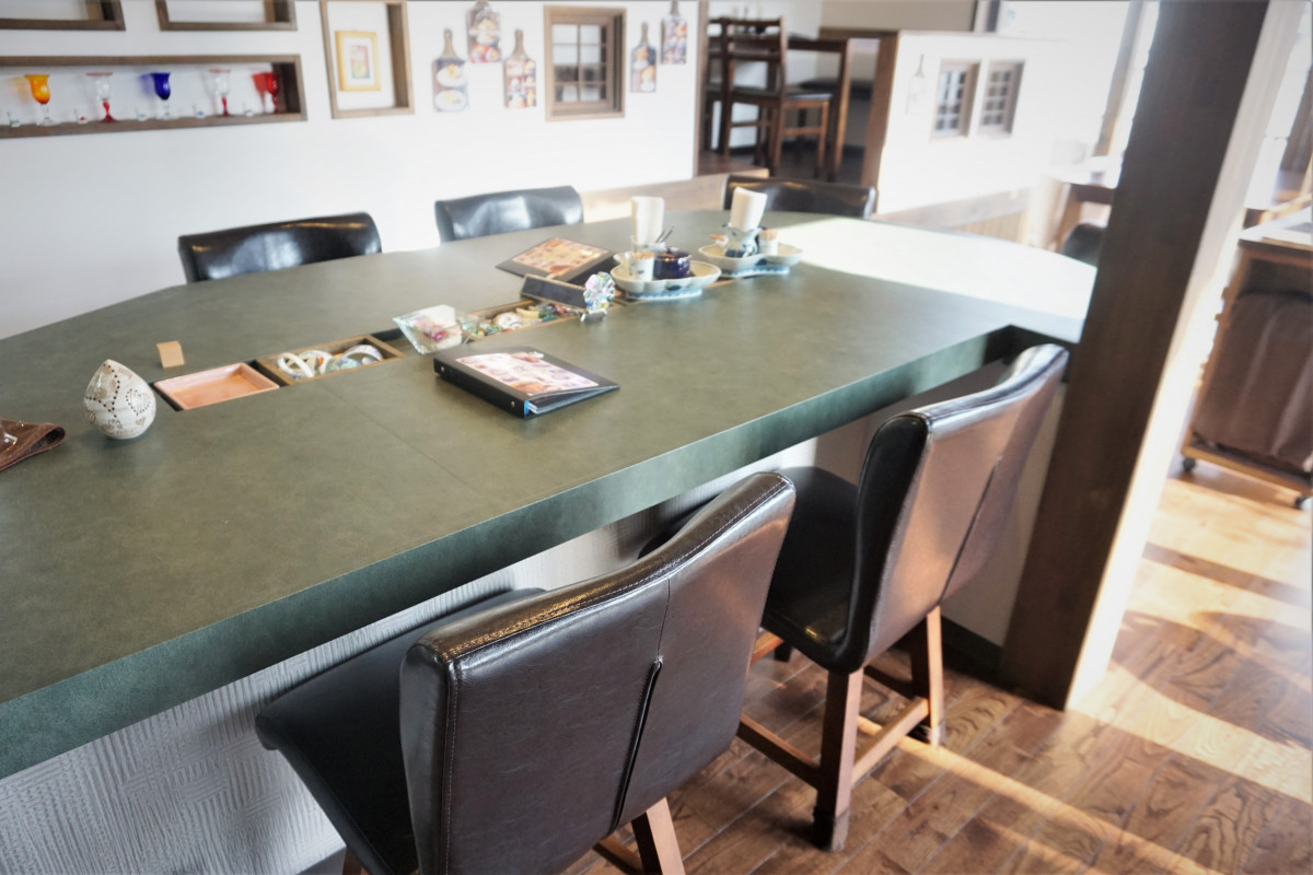 中央には大きなテーブル席、おひとりでご来店のお客様同士で会話が弾みます